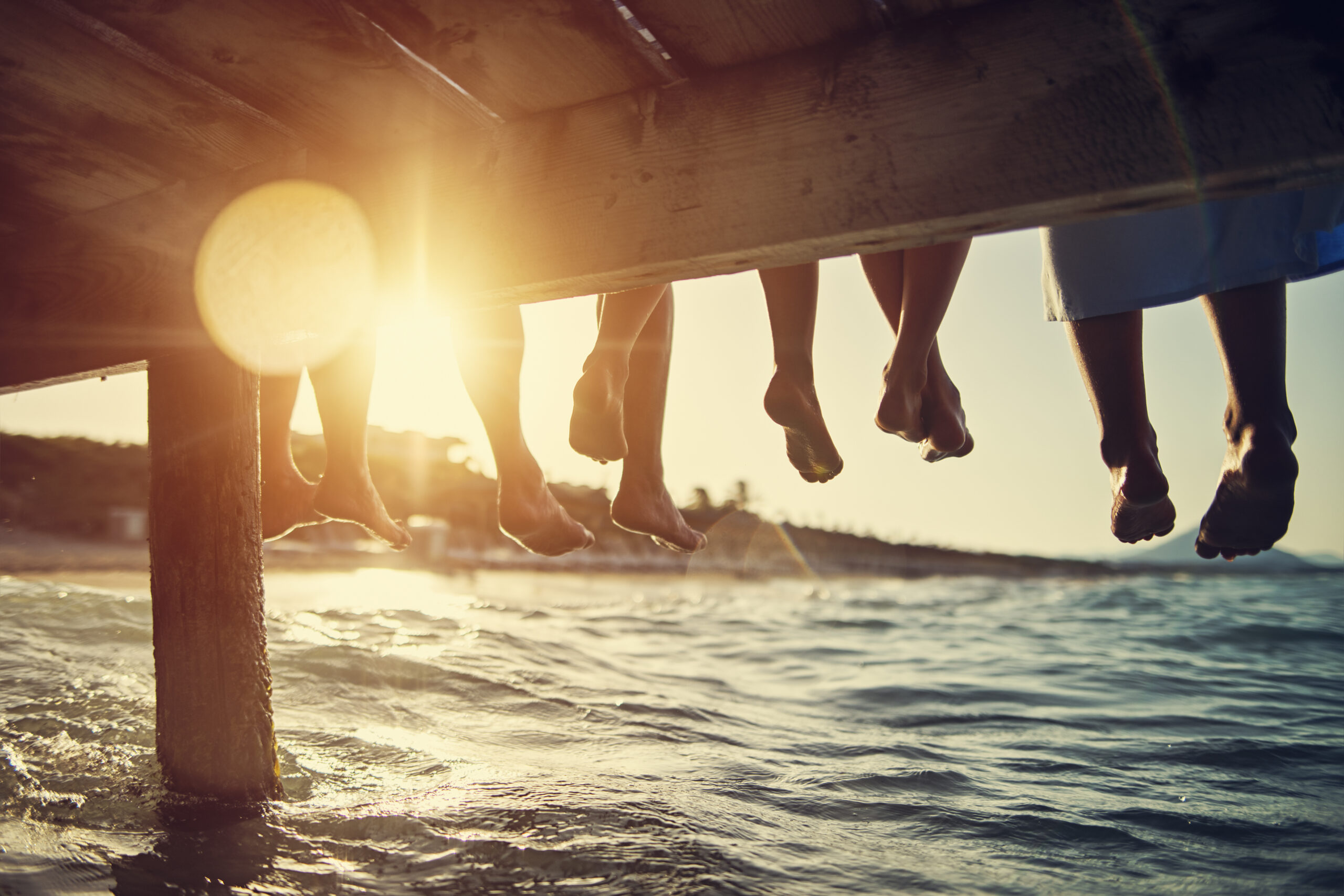 Family sitting on pier by the sea